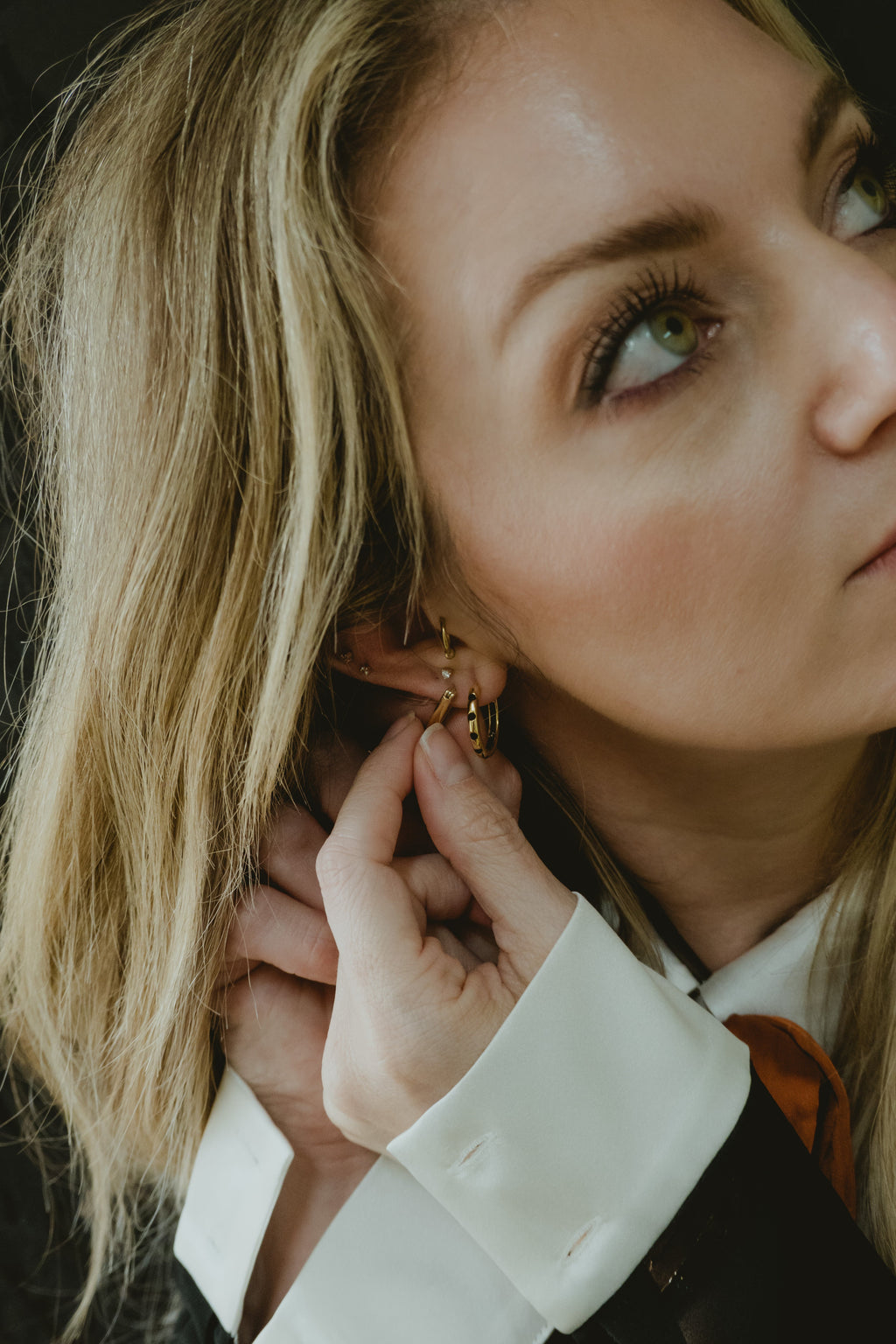 Model wearing The A’s gold huggie earrings