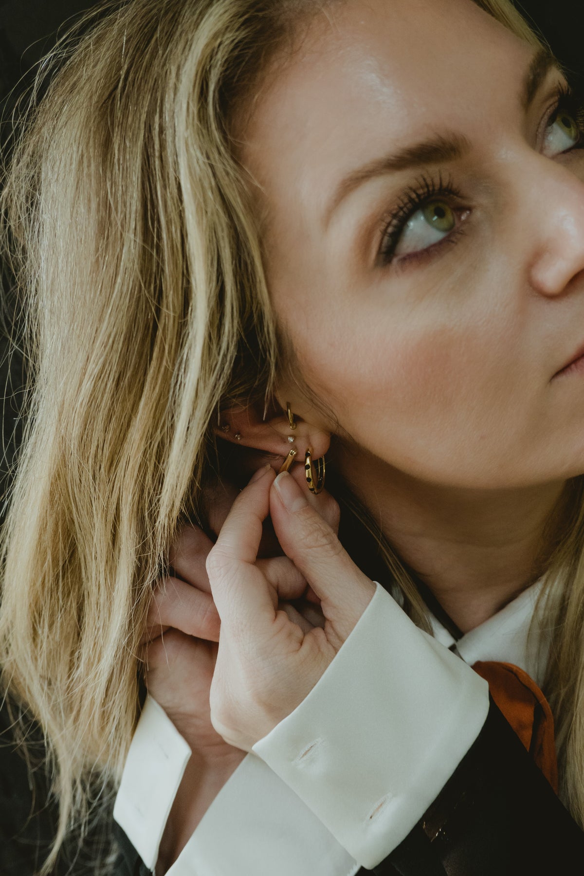 Model wearing The A’s gold huggie earrings