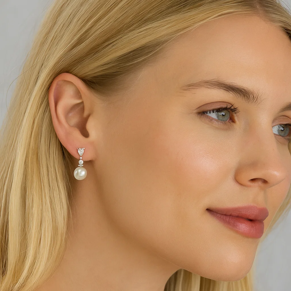 Pearl drop earrings with cubic zirconia accents worn on model