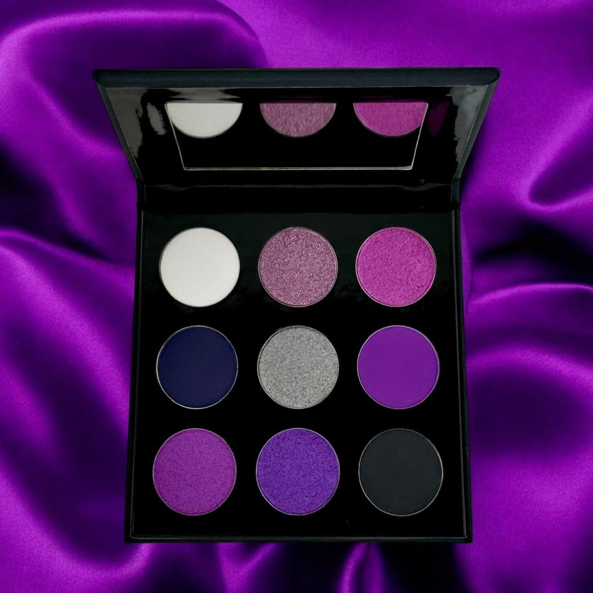 Open REIGN eyeshadow palette with purple-toned matte and shimmer shades